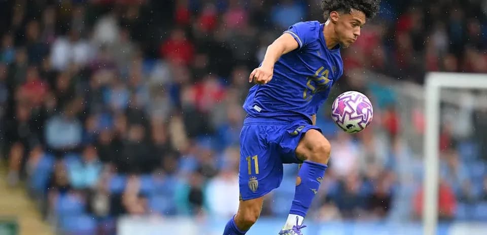 Joueur en action dribblant avec le ballon sous la pluie