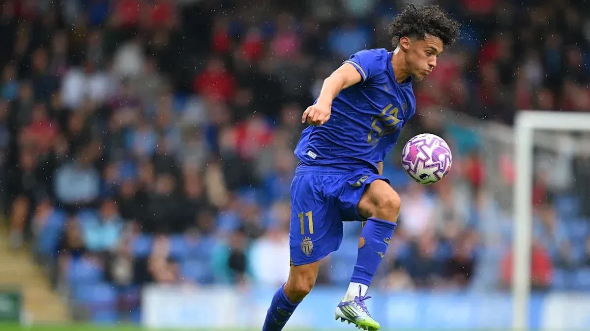 Joueur en action dribblant avec le ballon sous la pluie