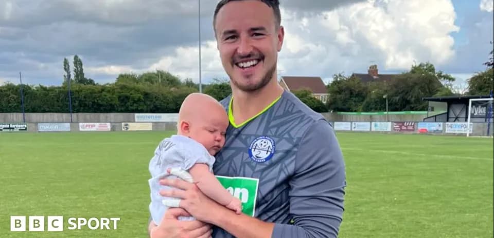 Gardien tenant un bébé sur un terrain de football