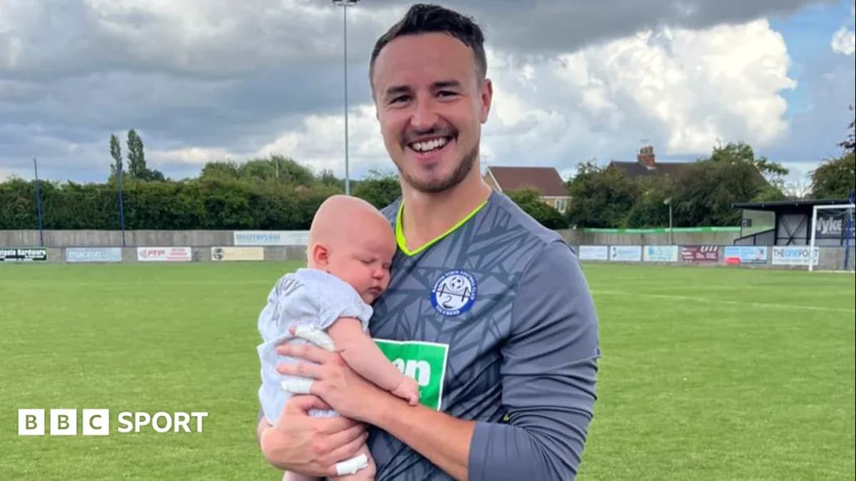 Gardien tenant un bébé sur un terrain de football