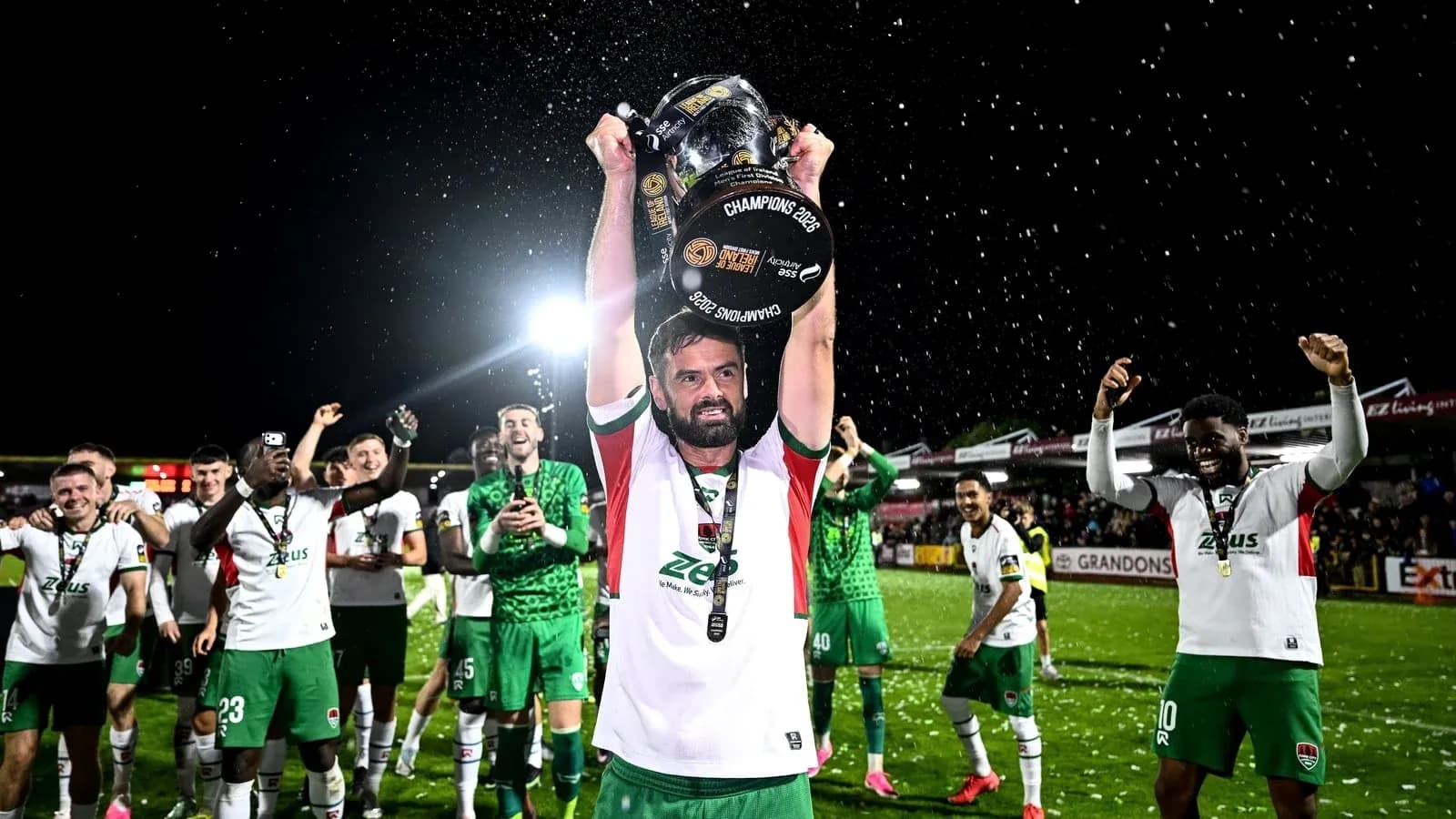 Joueur levant le trophée avec ses coéquipiers célébrant