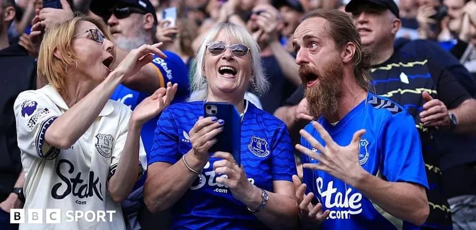Supporters celebrating in Everton jerseys at match