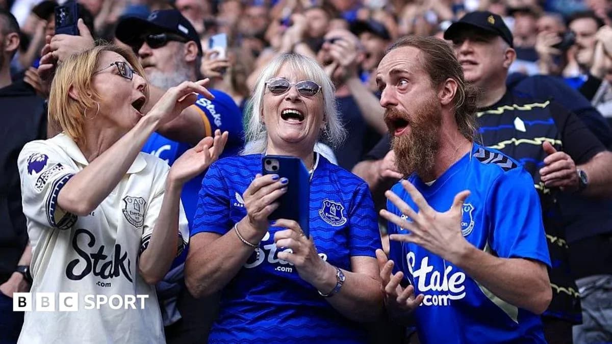 Supporters celebrating in Everton jerseys at match