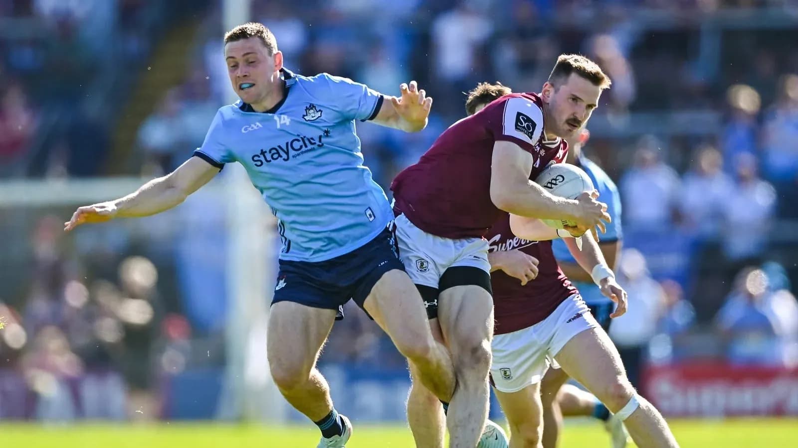 Joueur de Galways portant le ballon, attaqué par un joueur de Dublin
