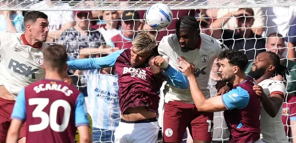 Joueurs en duel aérien près du but