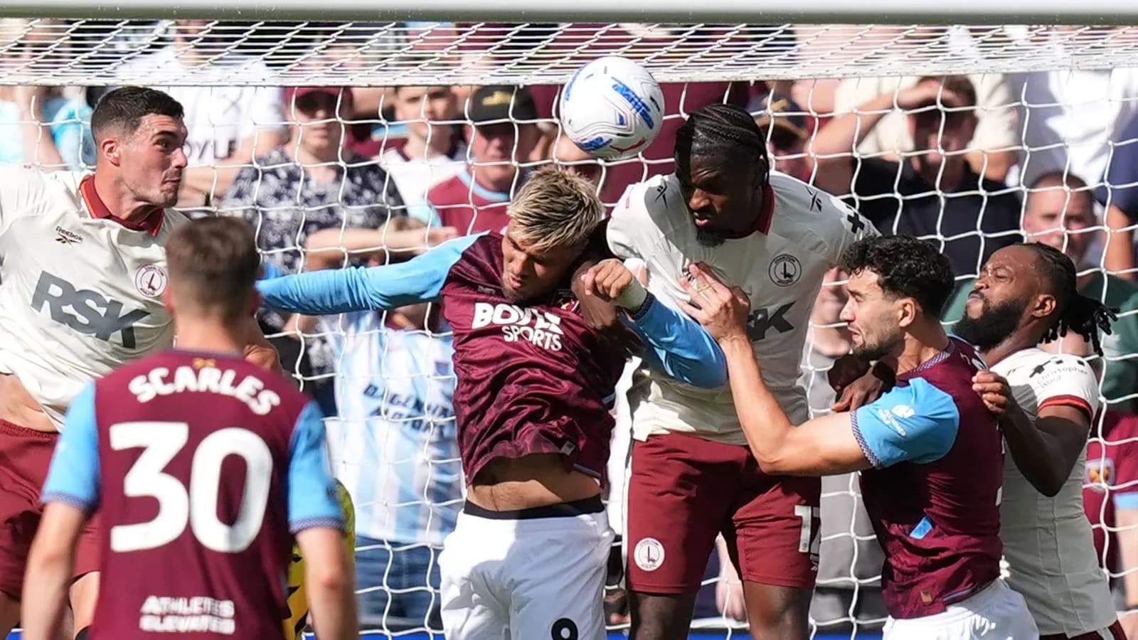 Joueurs en duel aérien près du but