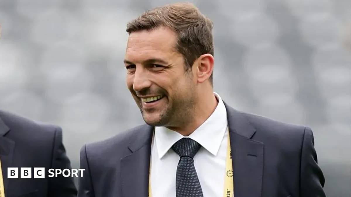Homme souriant en costume lors d'un événement sportif
