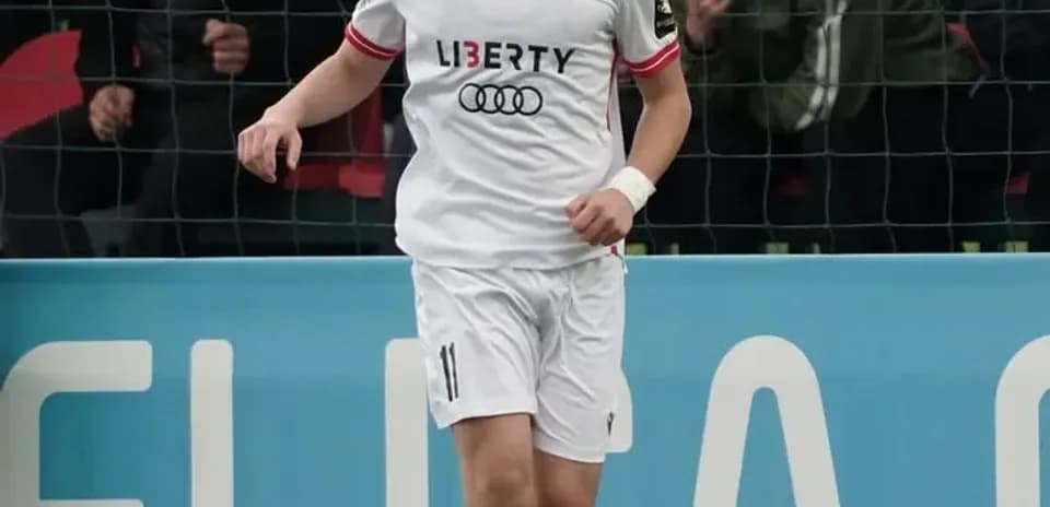 Joueur dribblant le ballon sur le terrain de football