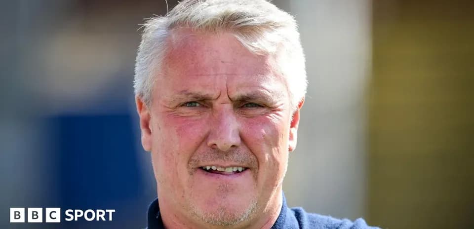 Entraîneur souriant devant un terrain de football