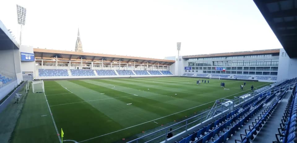 Stade avec terrain et joueurs en entraînement