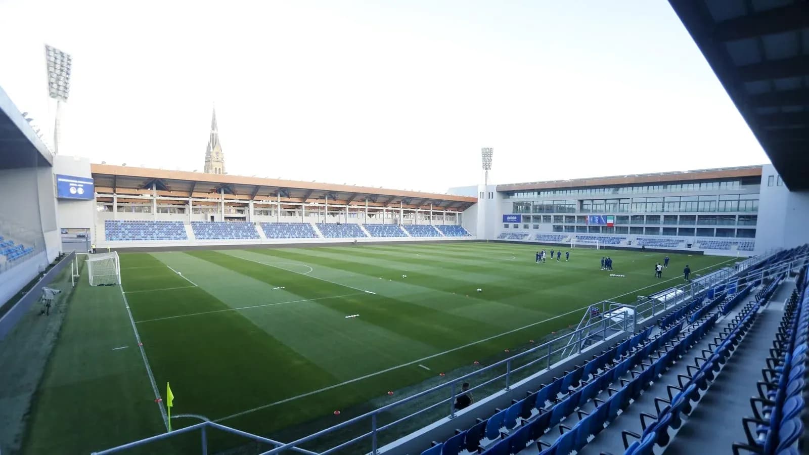 Stade avec terrain et joueurs en entraînement