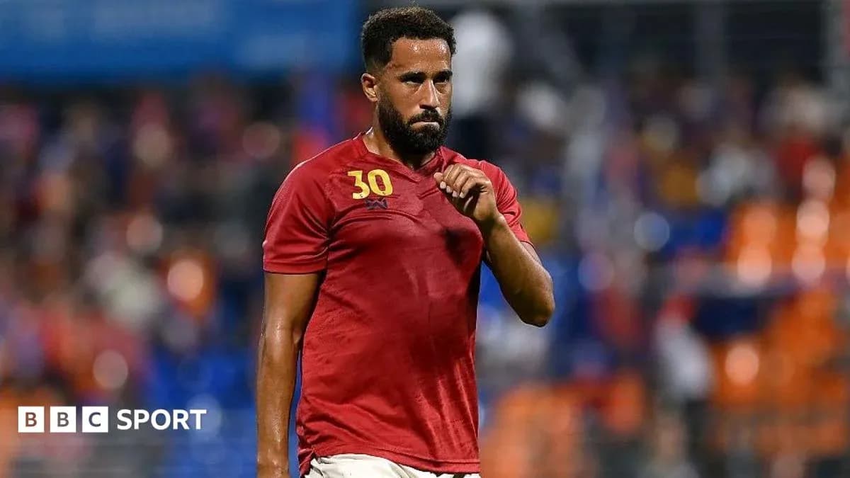 Joueur en tenue rouge marchant sur le terrain