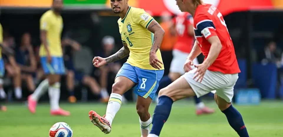 Joueur brésilien dribblant un adversaire norvégien
