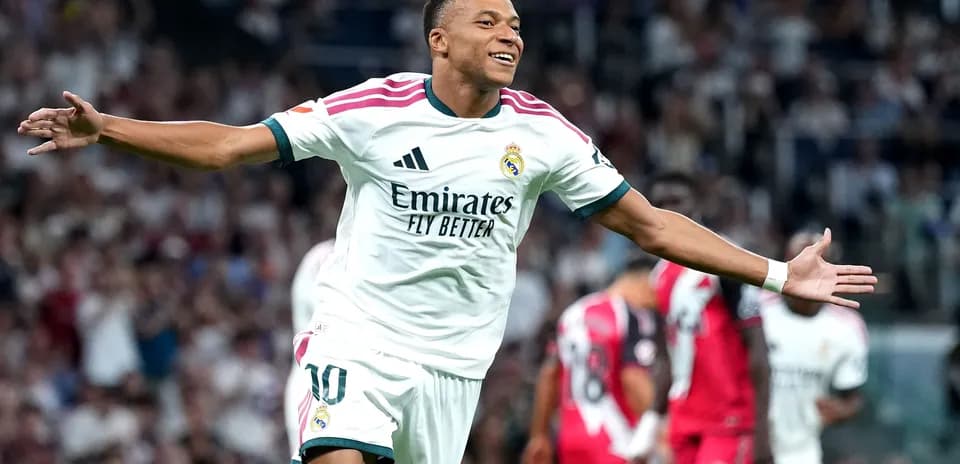 Joueur de football célébrant un but avec les bras ouverts