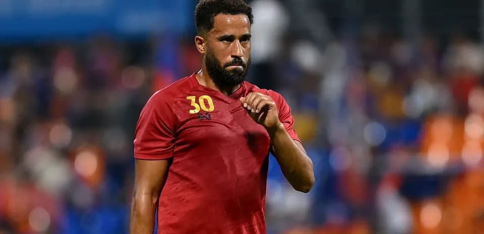 Joueur en maillot rouge sur le terrain de football