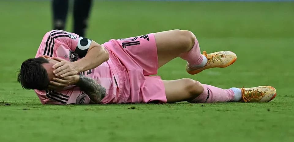 Joueur allongé sur le terrain, se tenant le visage