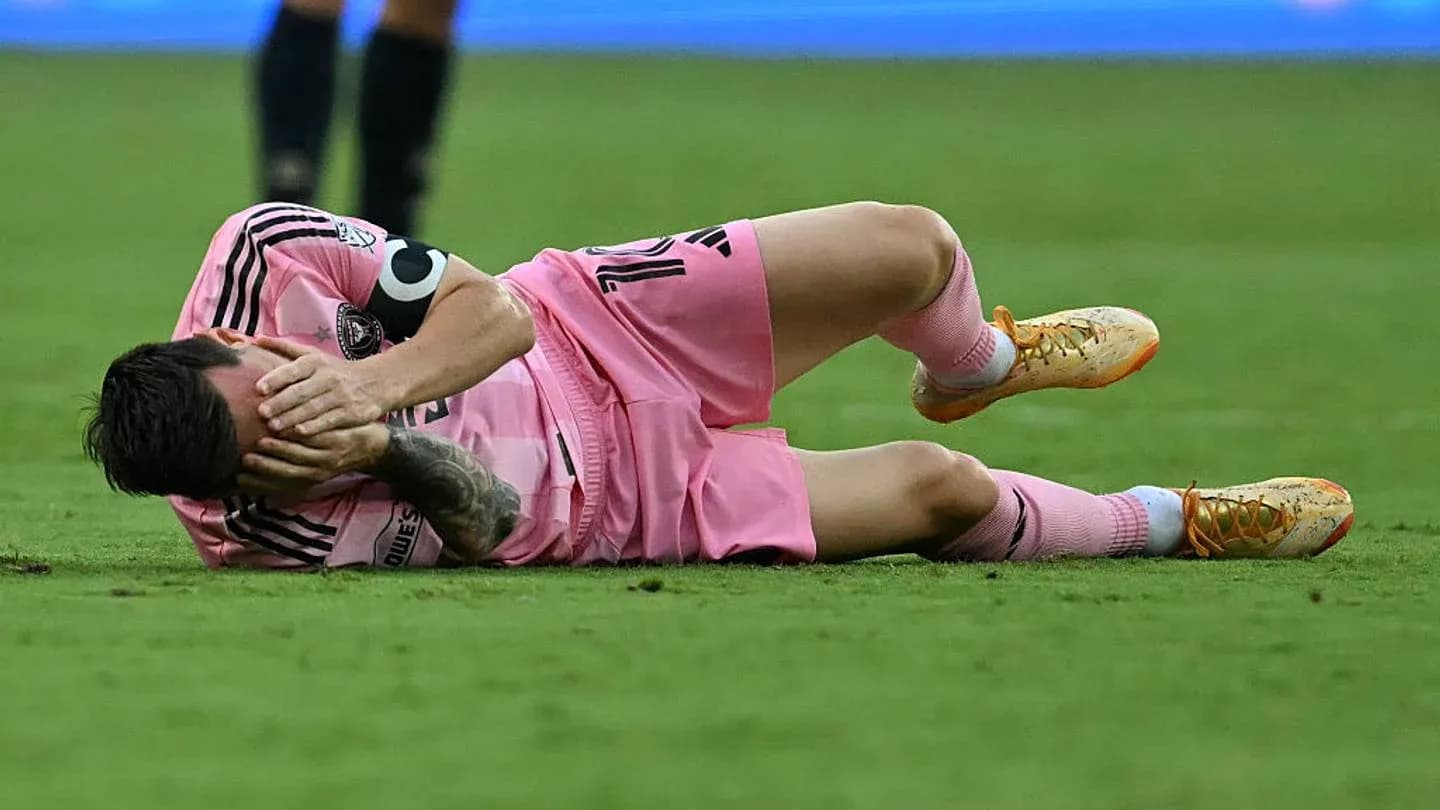 Joueur allongé sur le terrain, se tenant le visage