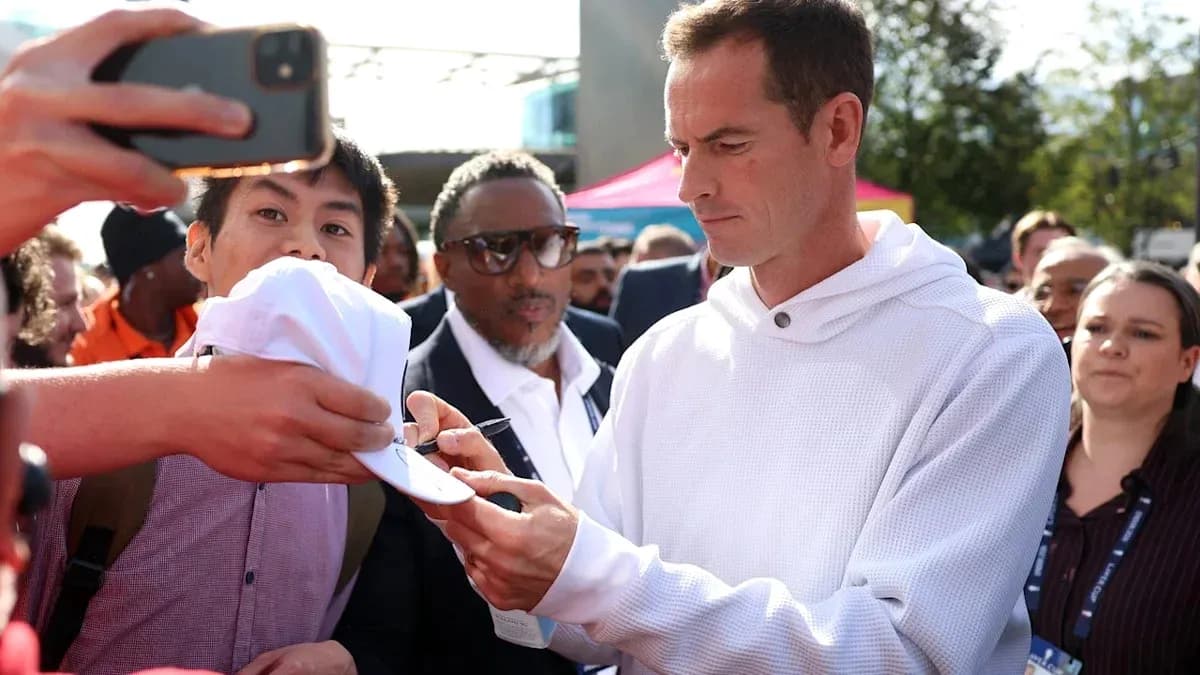 Athlete signing a cap for fans in crowd
