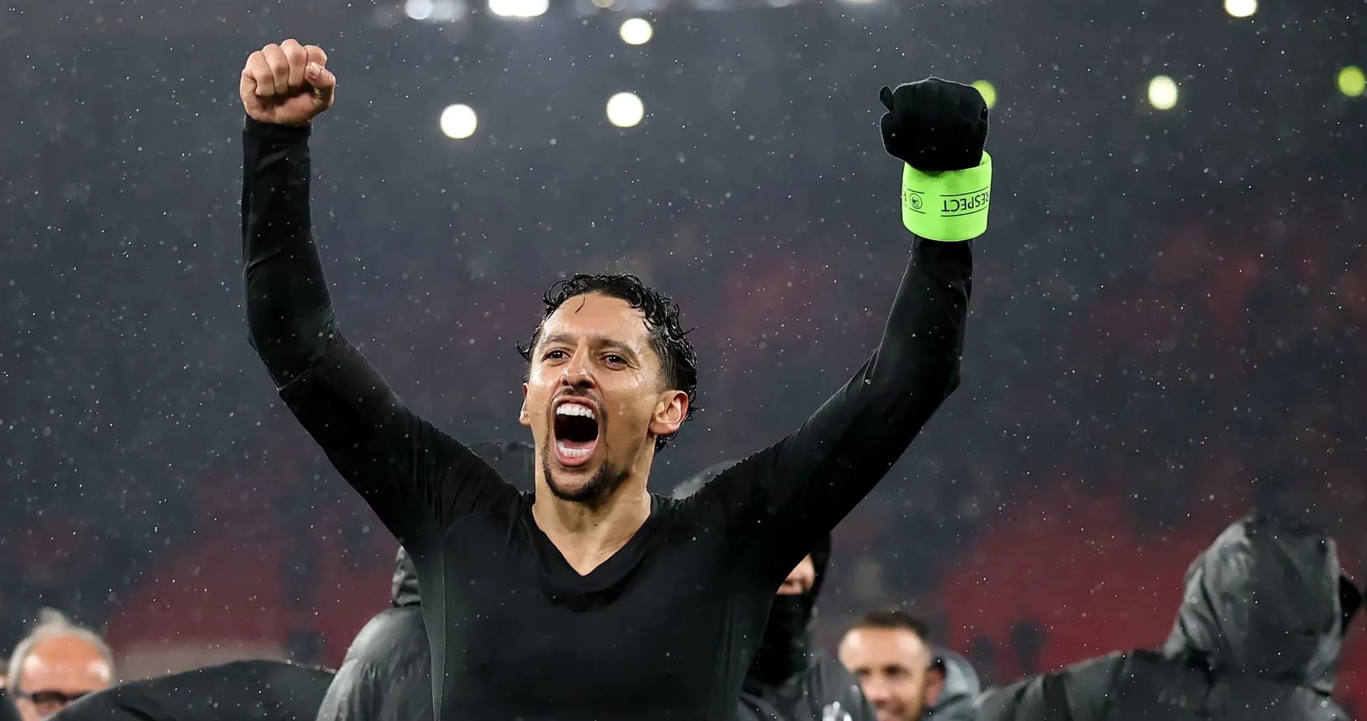 Joueur célébrant sous la pluie après le match