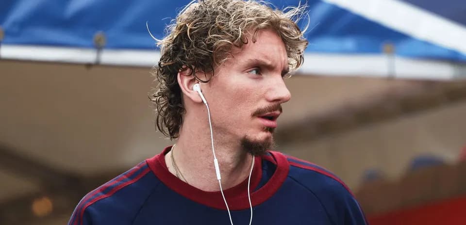 Athlete wearing earphones, walking outdoors