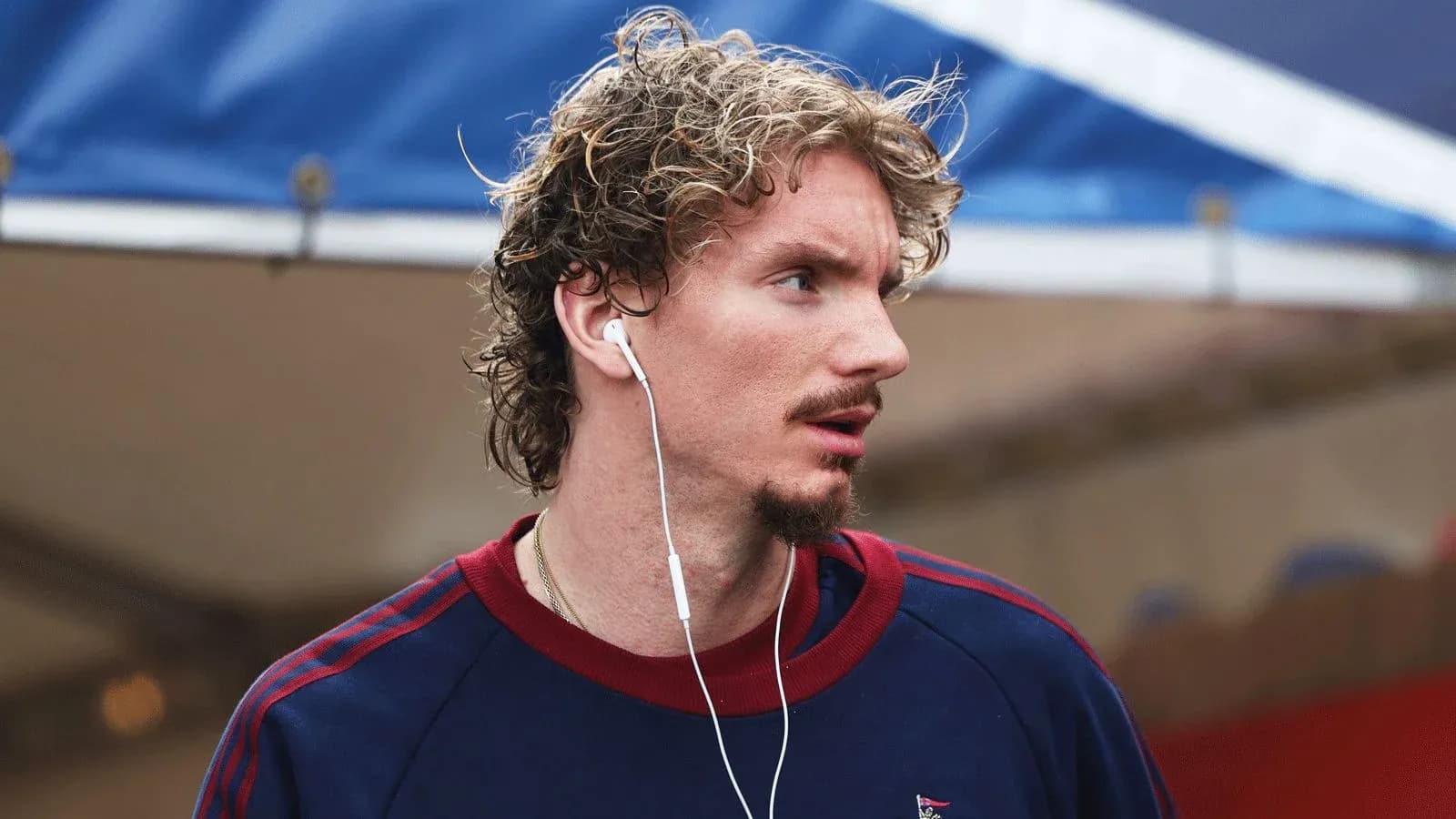 Athlete wearing earphones, walking outdoors