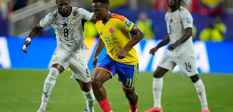Joueur colombien dribblant un adversaire ghanéen en match