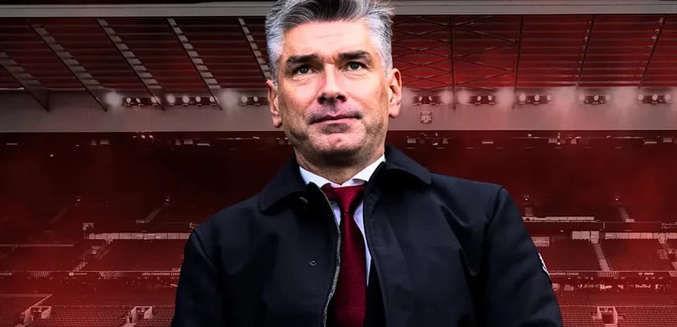 Entraîneur posant devant un stade de football