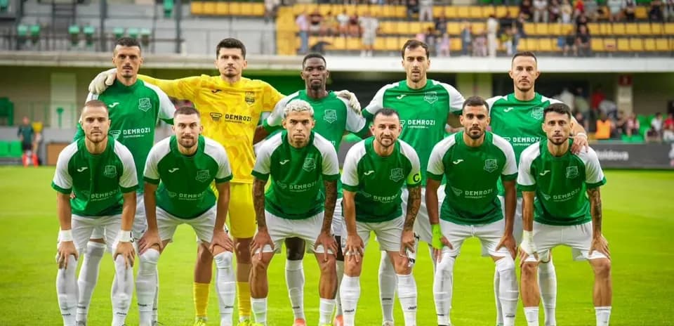 Équipe de football en tenue verte sur le terrain