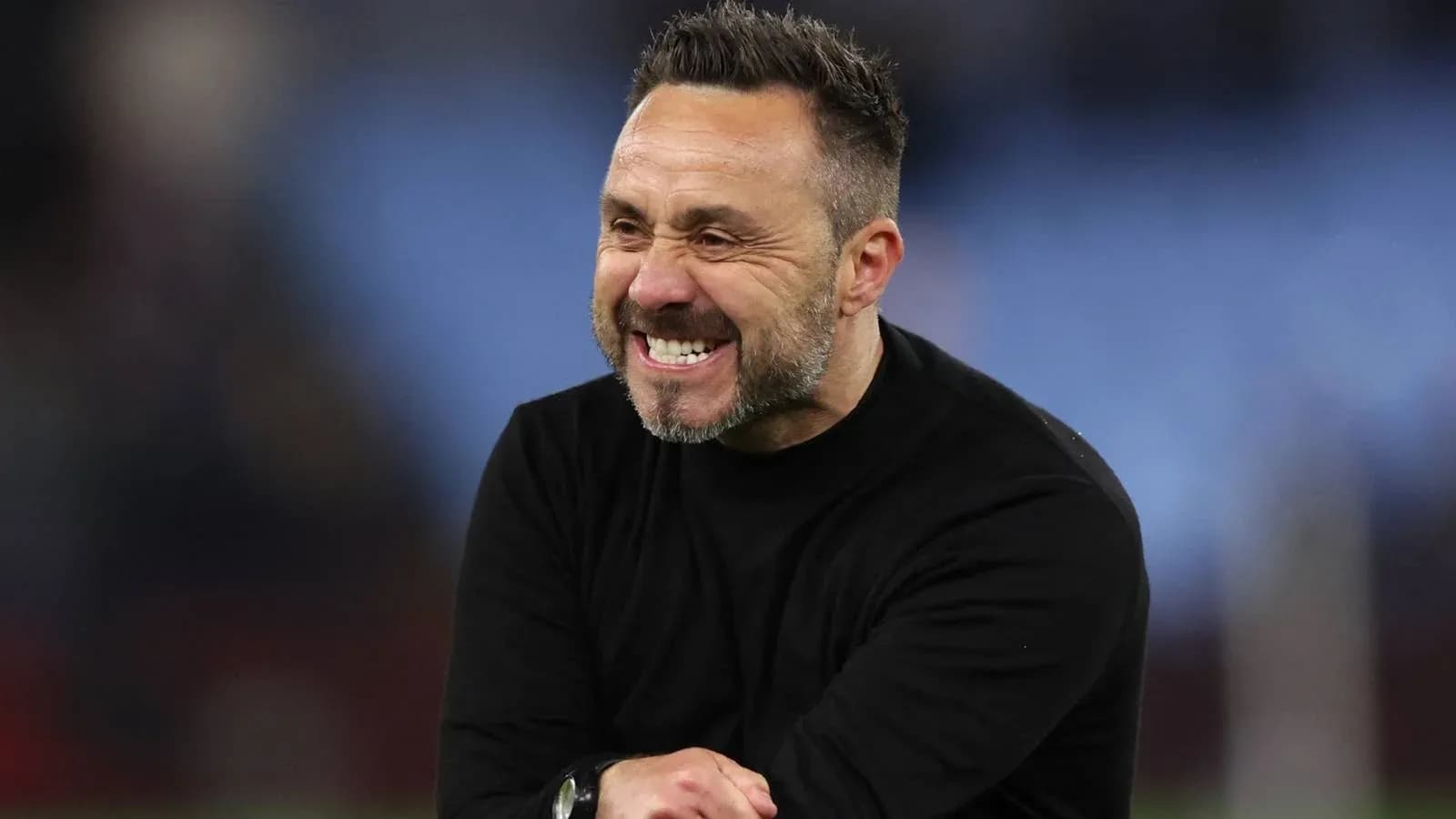 Entraîneur souriant sur le terrain après le match