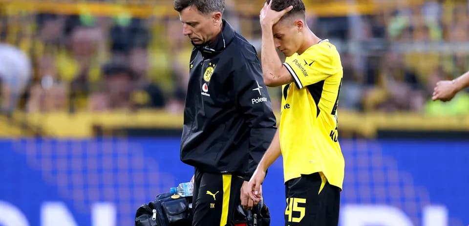 Joueur de Dortmund se faisant aider par le staff médical