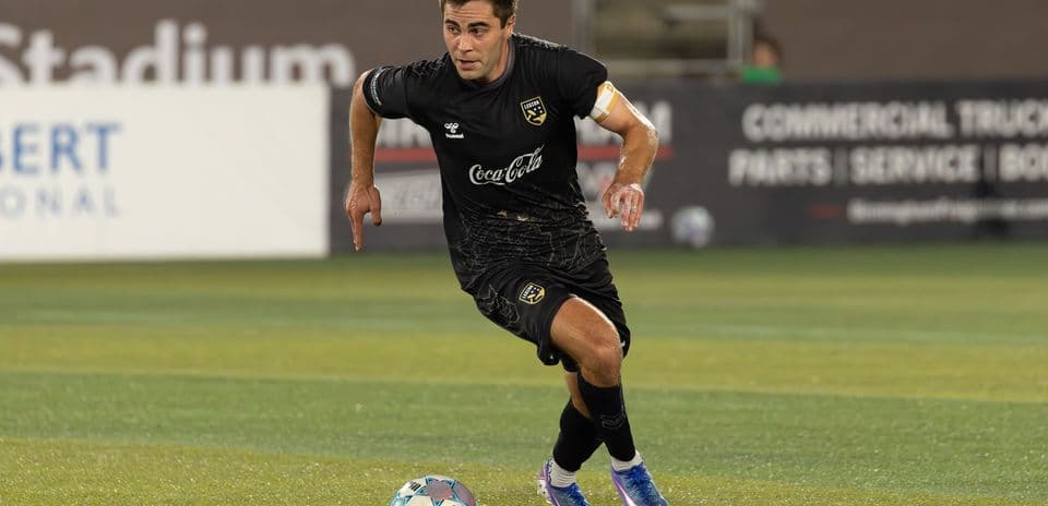 Un joueur dribble le ballon sur le terrain