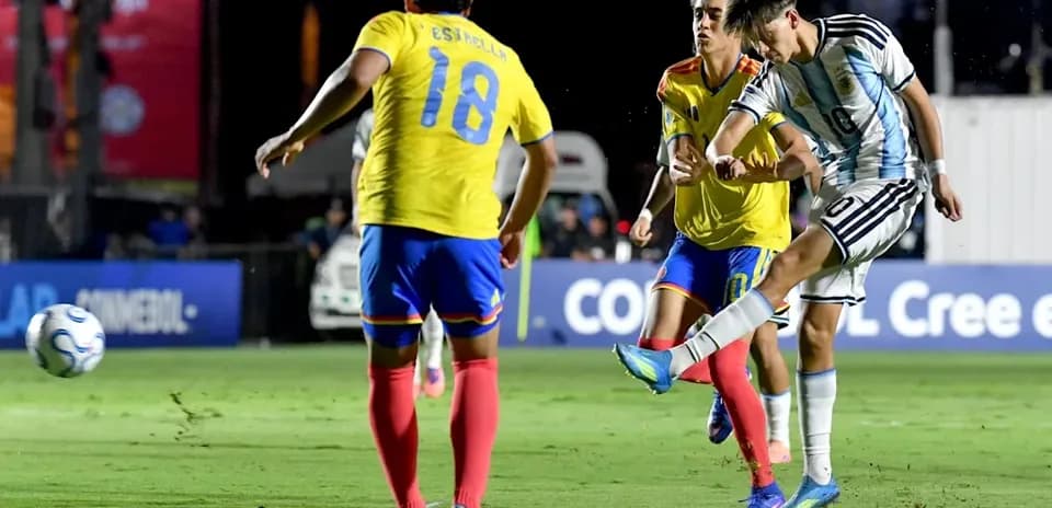 Joueur argentin tirant au but contre des adversaires