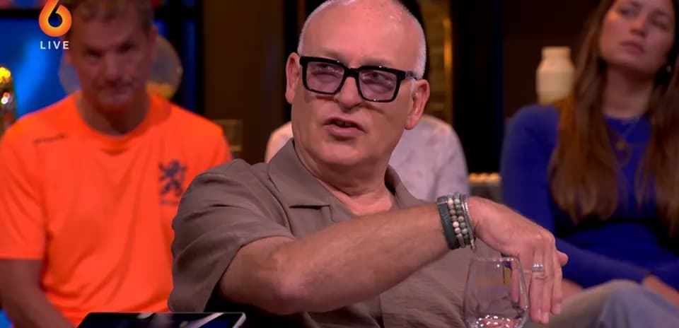 Homme parlant avec un verre de vin en main