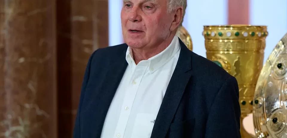 Homme parlant devant des trophées dorés