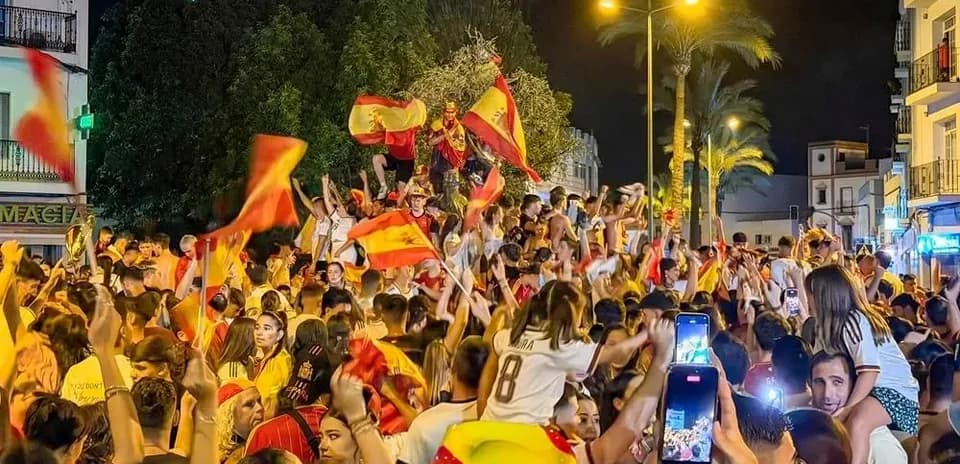 Foule célébrant avec drapeaux espagnols en soirée