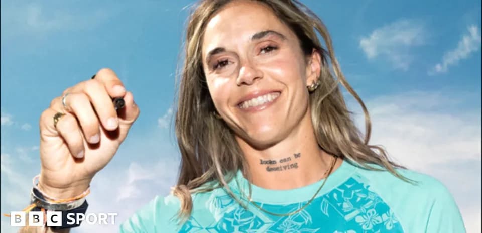 Athlete smiling and holding a pen against blue sky