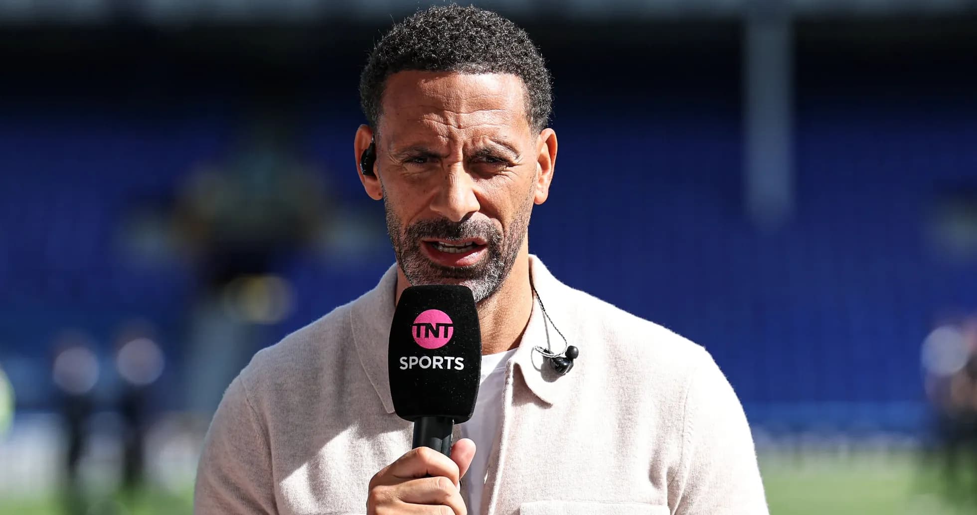 Présentateur parlant avec un microphone sur le terrain