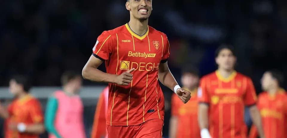 Joueur célébrant un but avec l'équipe en arrière-plan