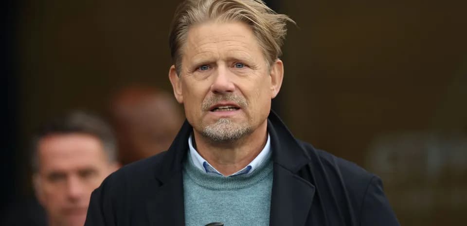 Homme au visage sérieux devant un groupe de personnes