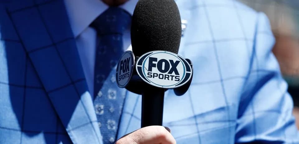 Microphone with FOX Sports logo in blue suit