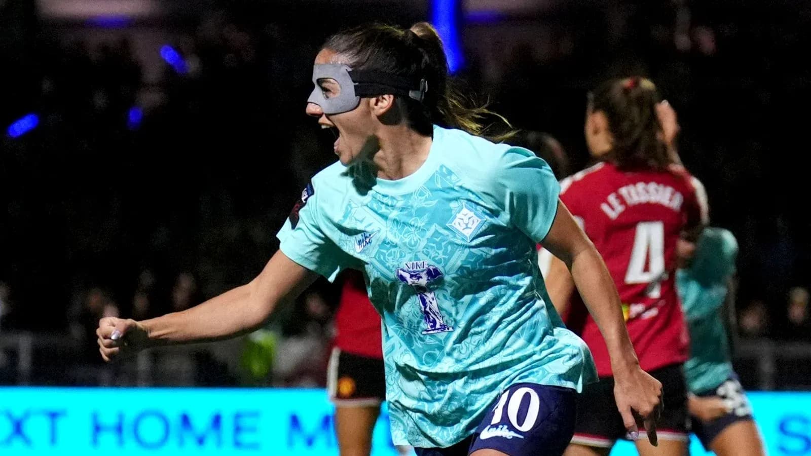 Joueuse célébrant un but avec un masque sur le visage