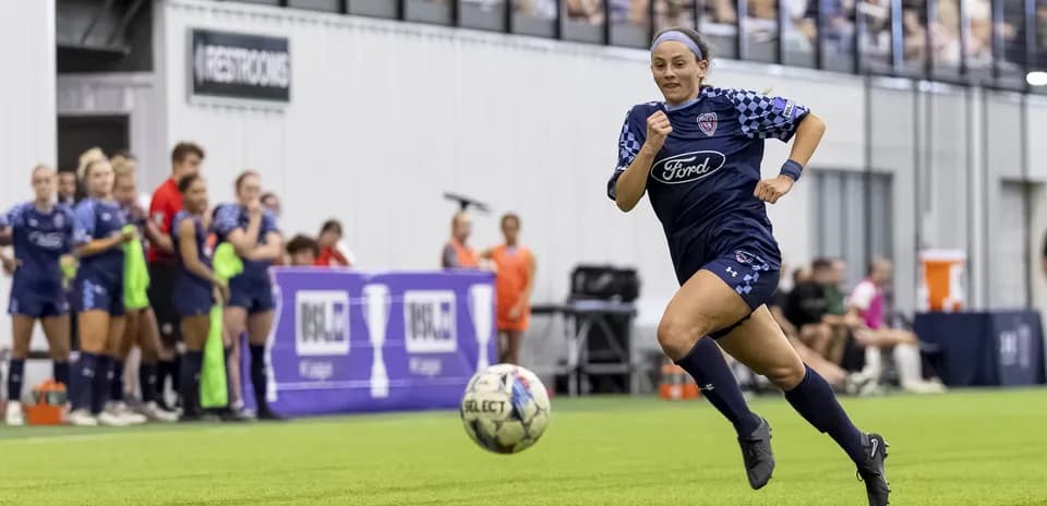 Joueuse courant avec le ballon sur le terrain