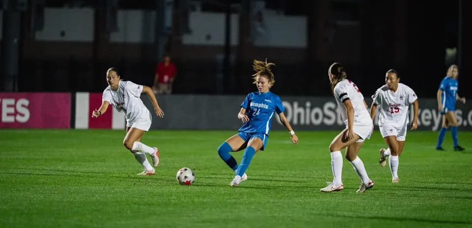 Joueuse dribblant le ballon entourée par des adversaires