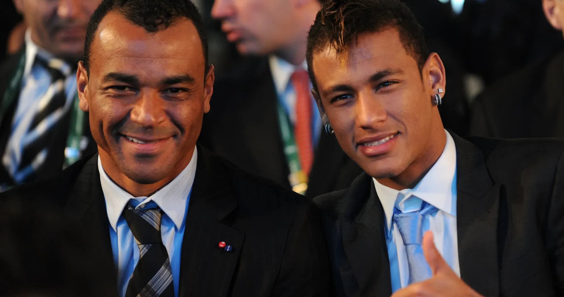 Deux hommes souriant en costume lors d'un événement