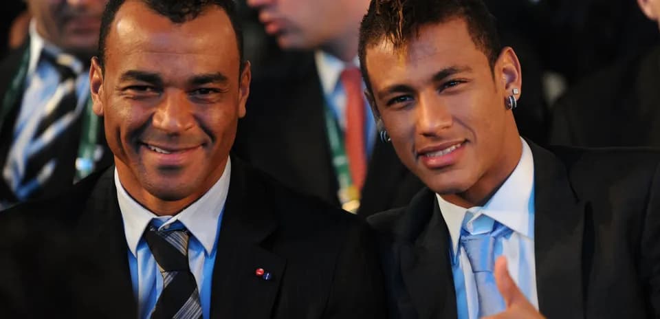 Deux hommes souriant en costume lors d'un événement