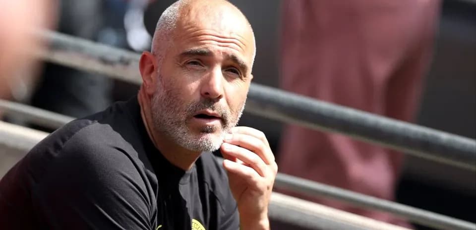 Entraîneur réfléchissant sur le banc de touche