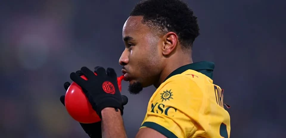 Joueur soufflant dans un ballon rouge pendant un match