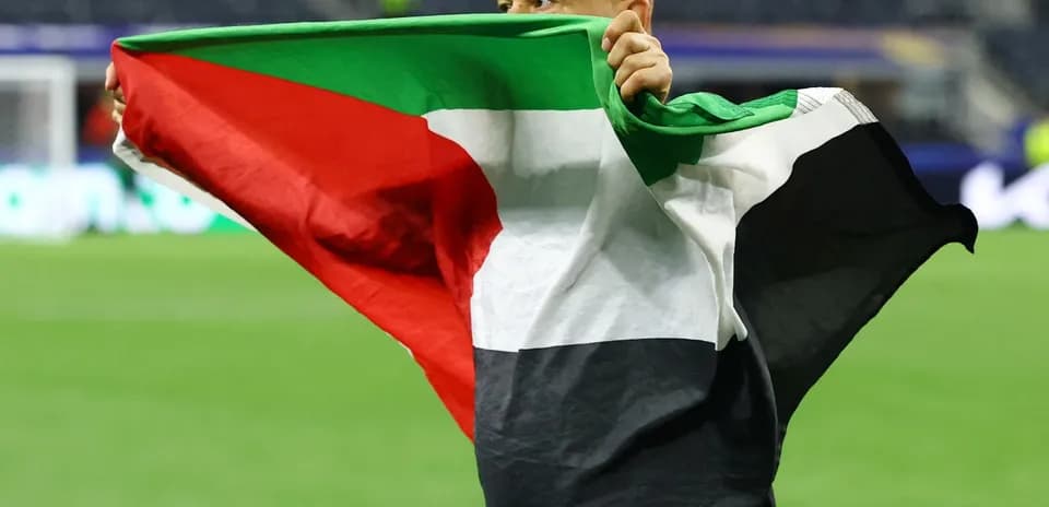 Homme tenant un drapeau sur le terrain de football