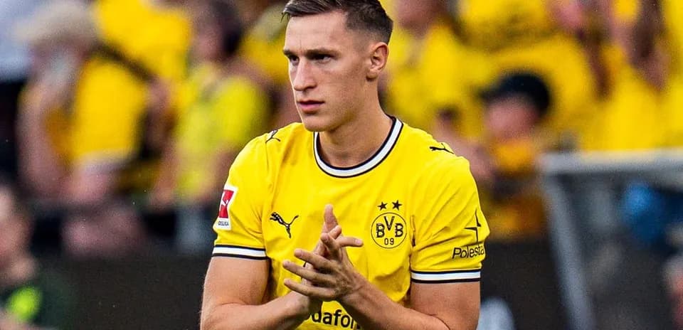 Joueur en maillot jaune de Dortmund applaudissant les supporters