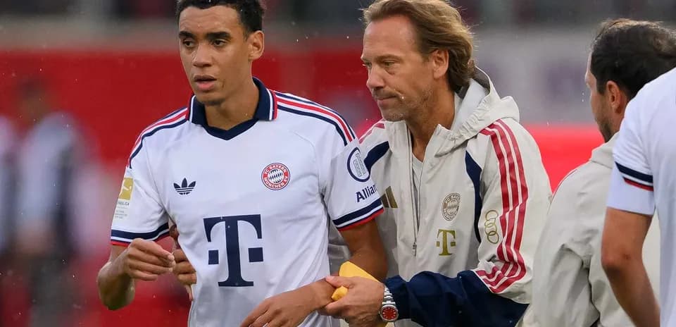 Joueur de Bayern Munich discutant avec entraîneur avant match